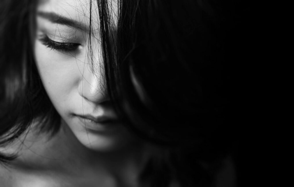 pexels-photo-594421-594421 Monochrome close-up of a young woman with a thoughtful expression, emphasizing emotions.
